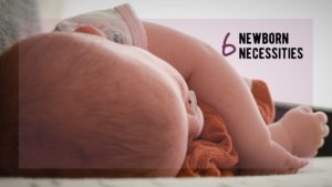 Little baby sleeps on their side while hugging a small blanket