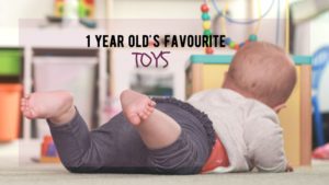 Baby lies on stomach playing with toys