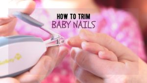 woman holds baby's hand ready to clip the baby's nails